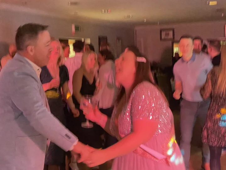 Wedding guests dancing on dancefloor with red DJ lighting - Essex wedding