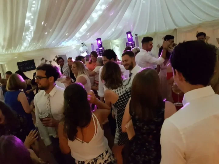 Wedding marquee tent with purple DJ lighting and packed dancefloor