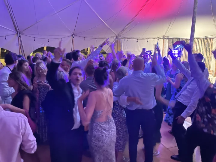 Wedding tent with packed dancefloor, purple lighting and fairy lights - Essex wedding DJ